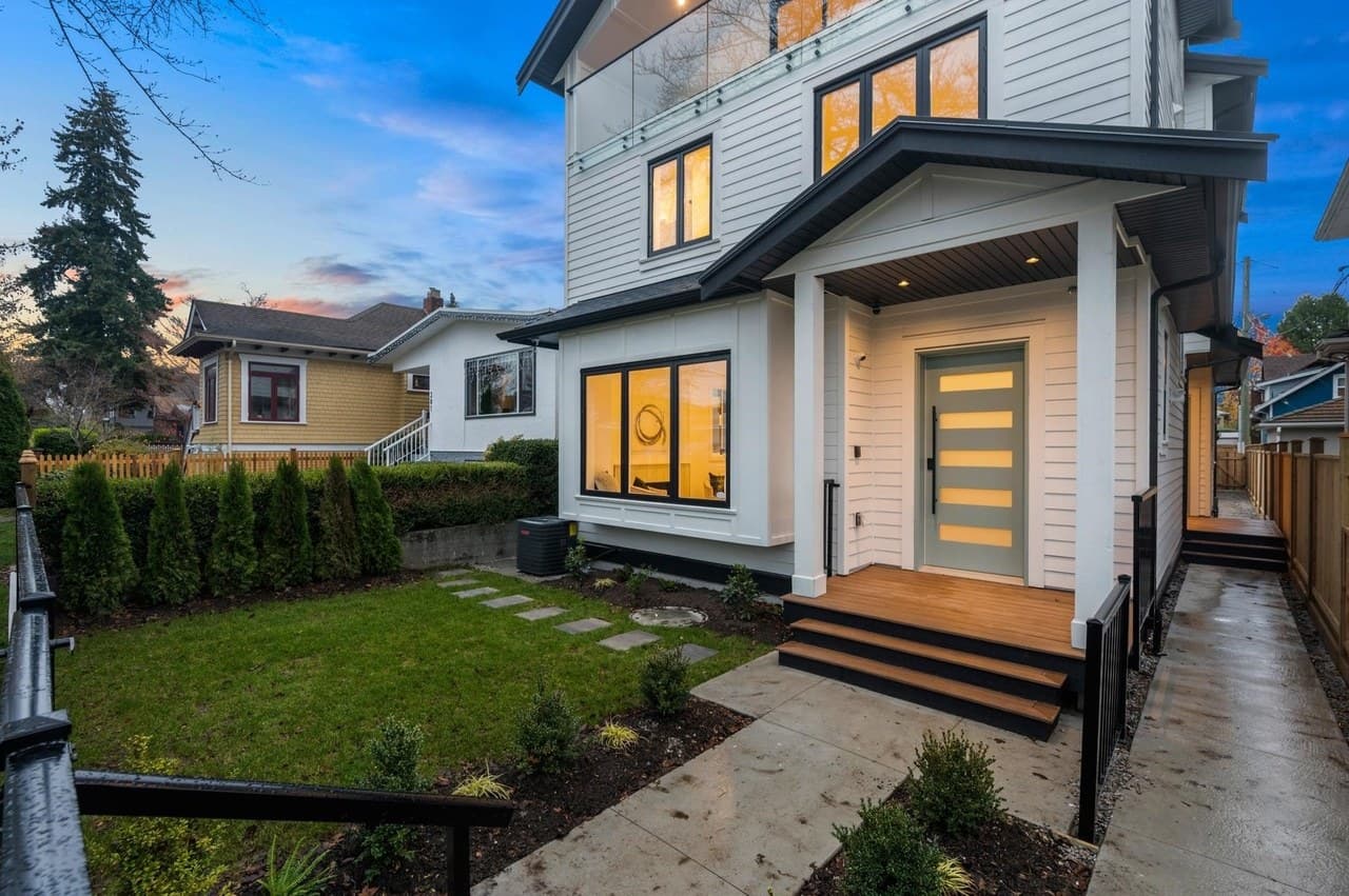 A Vancouver home with warmly lit windows at dusk